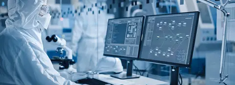 Person in protective gear using two computer monitors